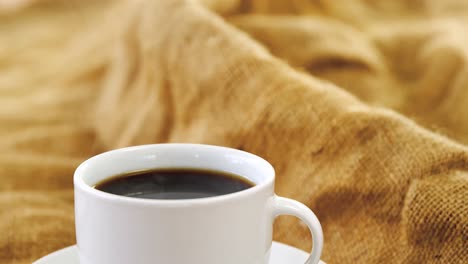 taza de café con granos de café en el saco