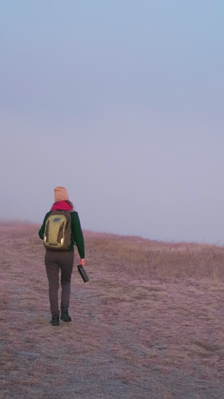 Woman Hiking in Foggy Field at Sunrise