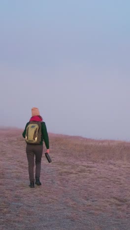 Woman Hiking in Foggy Field at Sunrise