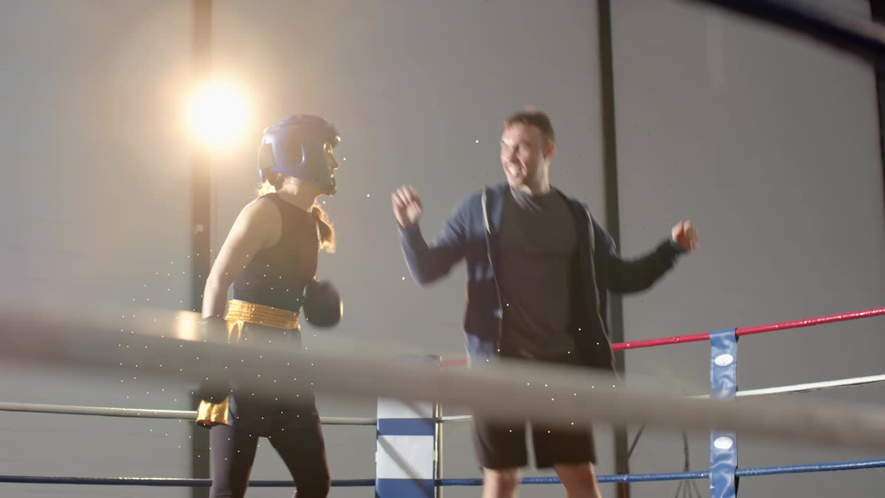 Blue headgear boxer raising arms as coach entering ring hugging, cheering boxing win, ropes flaring