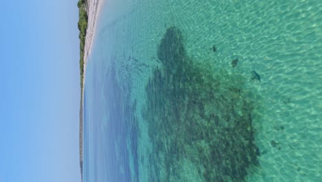 drone volando a baja altitud sobre las aguas poco profundas de la playa la cueva en la república dominicana