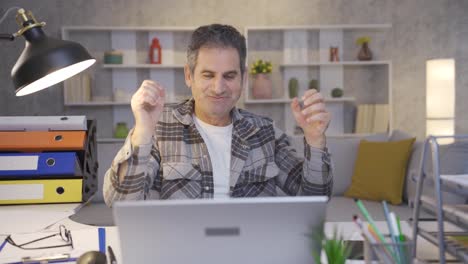 the mature man working in the home office is excited and delighted by the event he is waiting for.