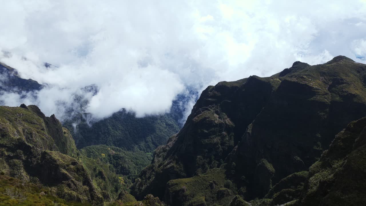 Pico do Arieiro mountains shrouded in low clouds, Madeira, Portugal. Aerial drone lateral view