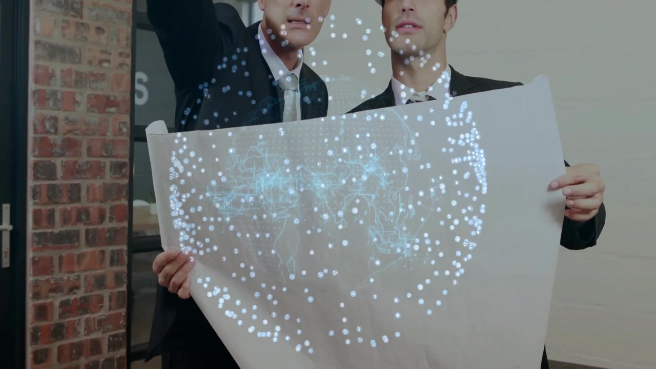 オフィスで白いシートを持つ2人のプロフェッショナルが、浮かぶホログラフィックデータグローブを表示している。