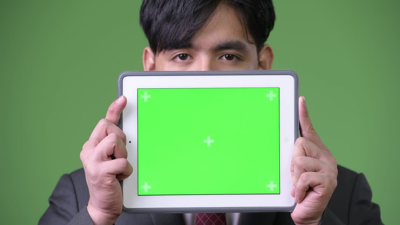 디지털 태블릿을 사용하는 젊은 잘생긴 아시아 사업가