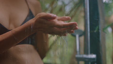 woman in shower catching water in hands enjoying refreshing cleanse showering outdoors in nature