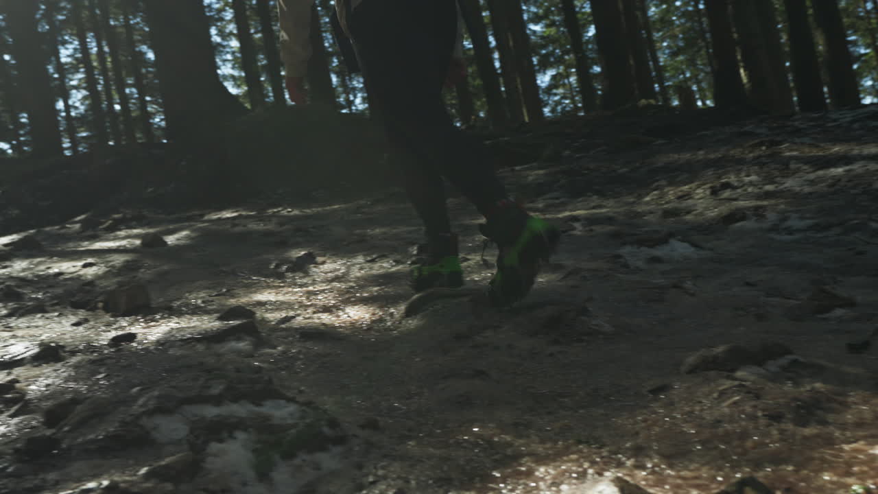 Caucasian woman hiking in a forest on a rocky mountain during the day, tracking gimbal shot