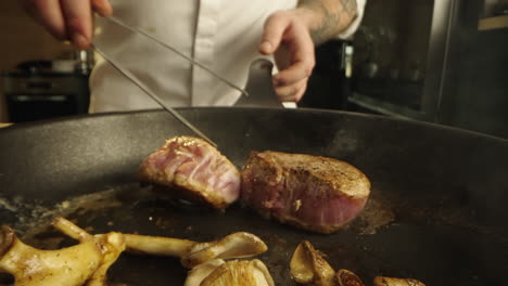 cooking meat and mushrooms in a pan