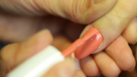 young woman getting her nails painted during a manicure