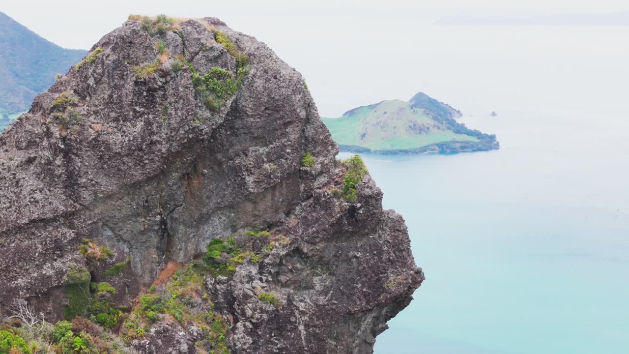 Drone-kuva rosoisista kiviyksityiskohdista ja kasvillisuudesta vuoren huipulla, kallionseinämällä, Northland Aotearoa