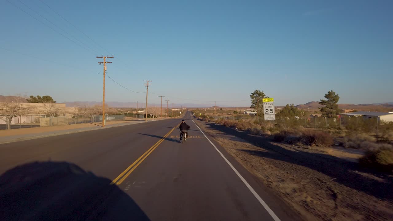 이 영화적 클립에서 열린 도로의 경험은 외로운 모험가가 사막의 중심에 있는 매력적인 오래된 농장을 지나 빈티지 헬리 ⁇ 터 오토바이를 타는 것을 포착합니다.