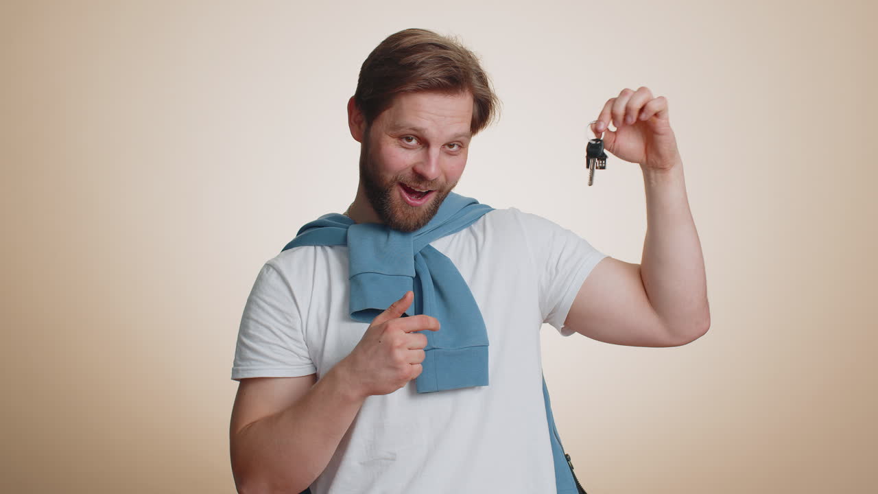 Happy man real estate agent showing keys of new home house apartment buying renting property