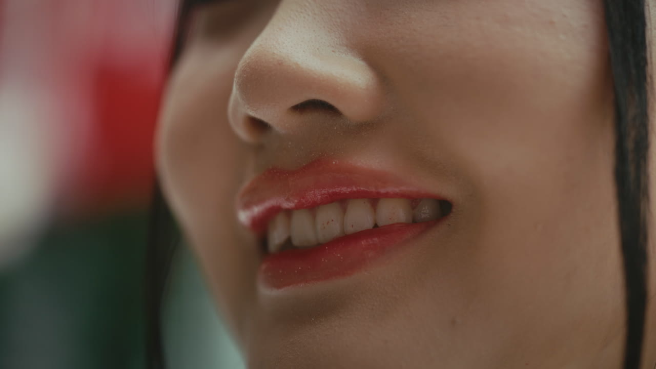 A close-up of a person smiling with bright lips, radiating joy and warmth