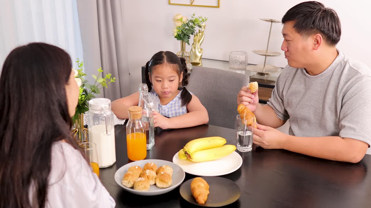 A family shares a joyful breakfast in a bright, cozy dining room, highlighting warmth and togetherness