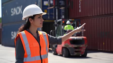 focused and determined: a young female professional overseeing container operations in a busy industrial port environment