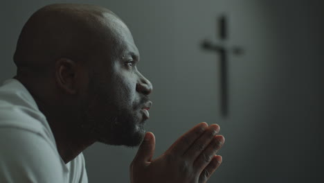 faithful man holding hands together and praying in church