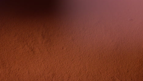 overhead shot of chocolate brownies being dropped into cocoa powder