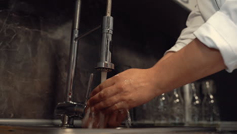 lavación adecuada de las manos en el fregadero de la cocina, antes de cocinar.