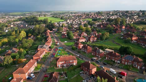 urban housing in the uk: red brick council estate in yorkshire, aerial drone view, bathed in morning sun, with homes and people