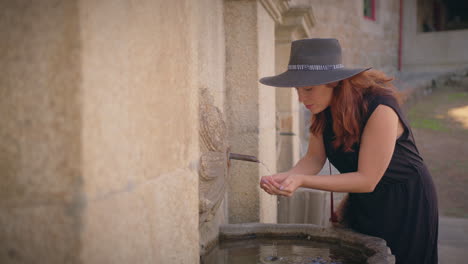 Una-Chica-Se-Acerca-A-Una-Fuente-Urbana-Y-Bebe-Agua-En-Cámara-Lenta.