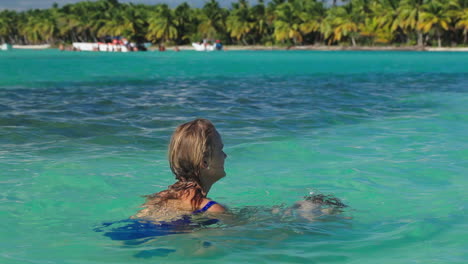 Madre-E-Hijo-Jugando-En-Agua-De-Mar-Clara