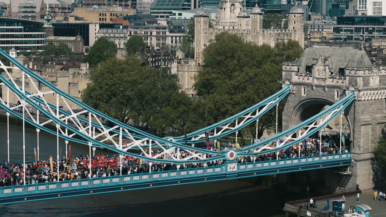 Wide aerial of marathon runners crossing Tower Bridge with Tower of London backdrop