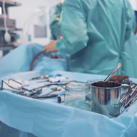 medical instruments on a sterile table in operating room. small table with medical tools for operation on the background of operating process.