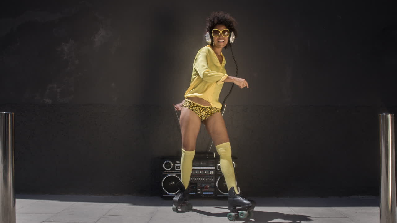 mujer de patinaje sobre ruedas baila y patina afuera en un entorno urbano