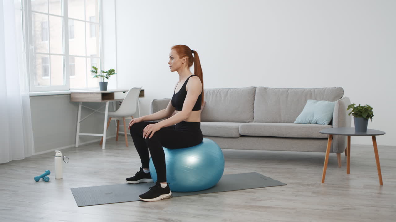 Woman doing exercise on a yoga ball at home
