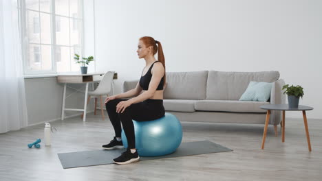 woman doing exercise on a yoga ball at home
