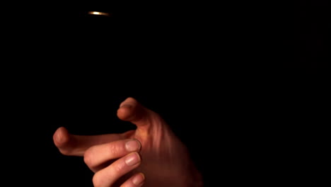 woman tossing a euro coin on black background