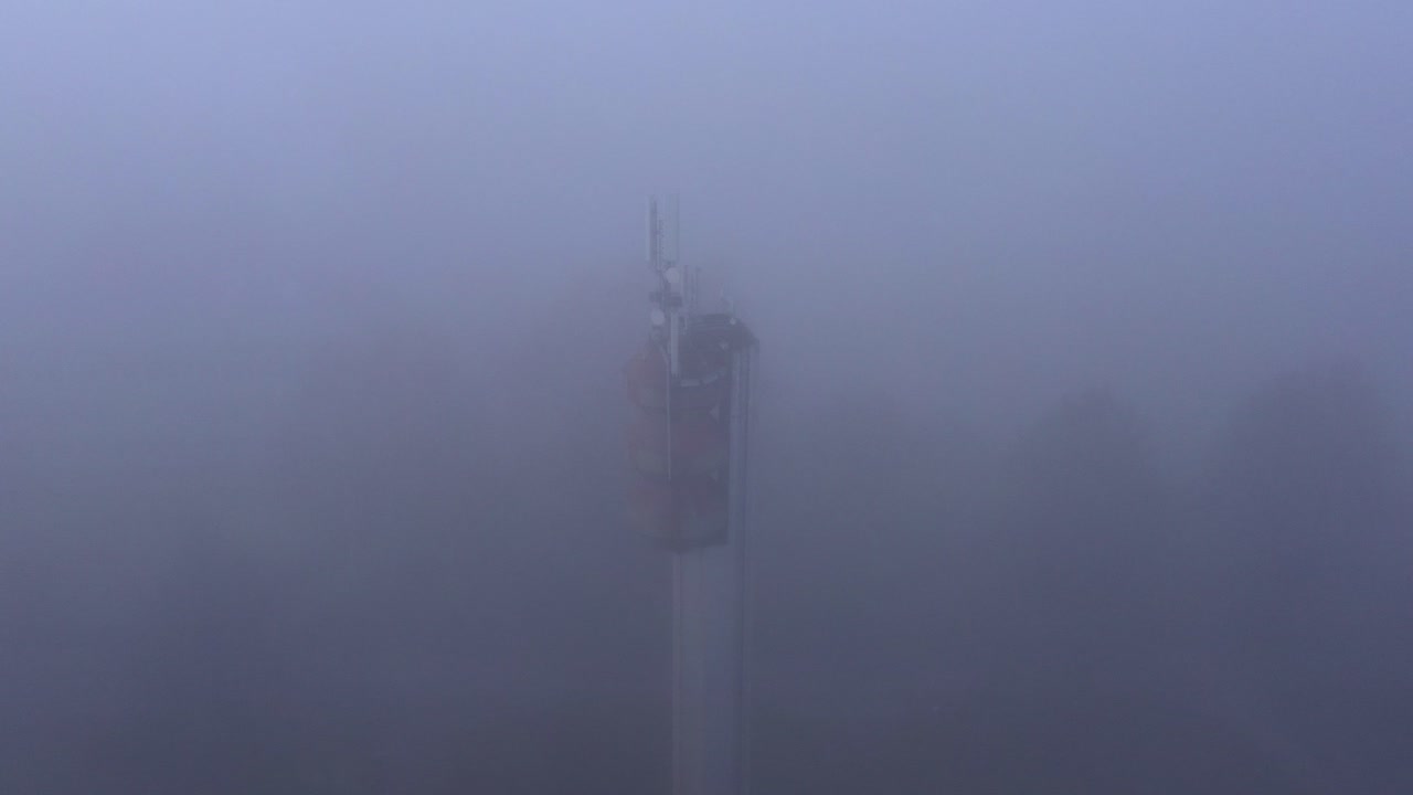 시야가 좋지 않은 짙은 안개 속 급수탑의 통신 안테나, 공중 기울기