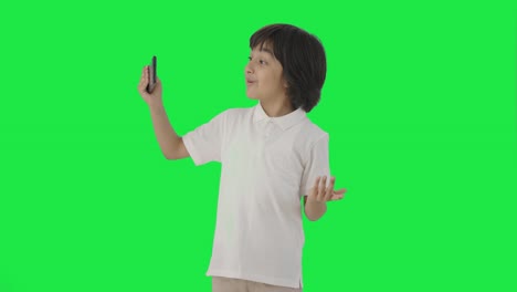 행복한 인디언 소년은 녹색 스크린으로 블로그를 만들고 있습니다.