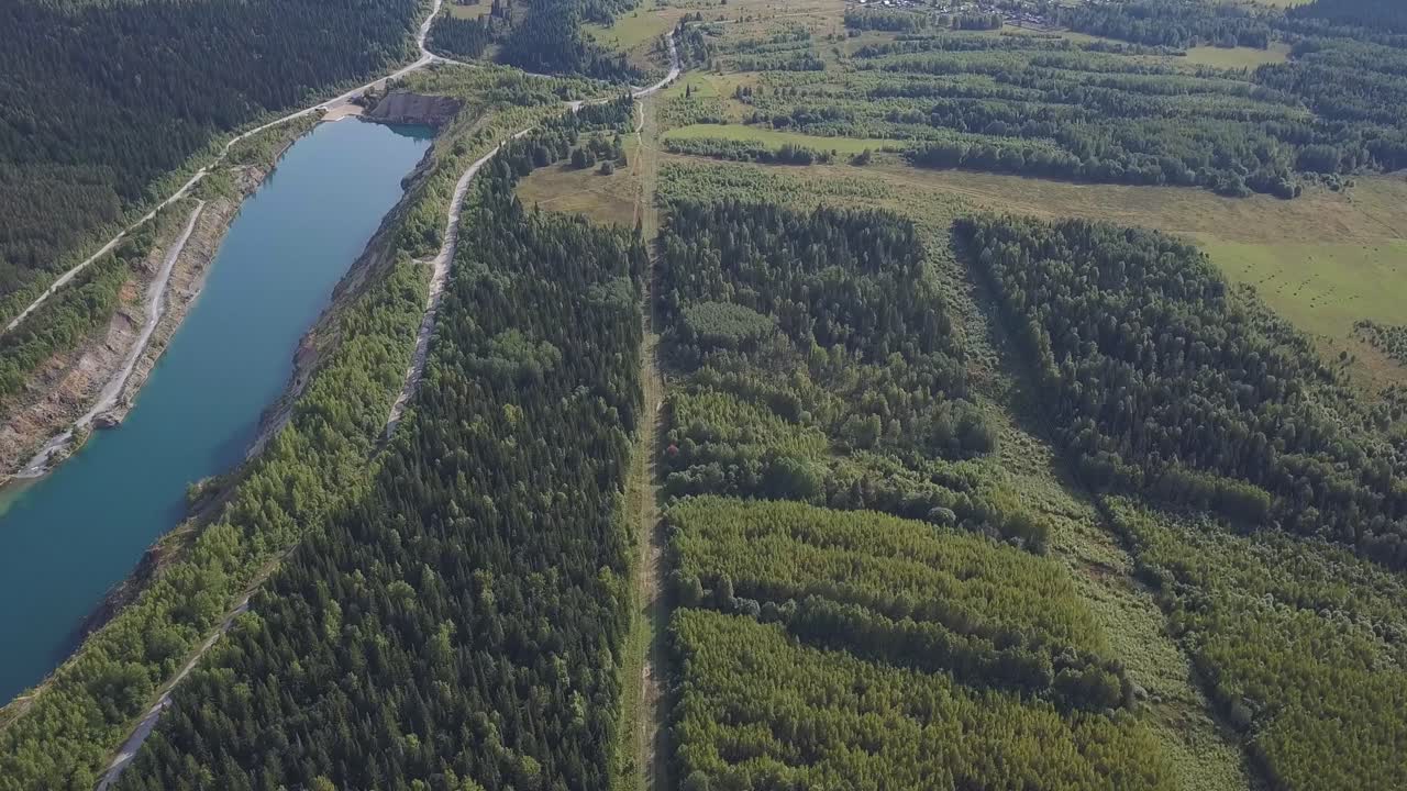 vista aérea de un paisaje pintoresco con un lago, un bosque y carreteras