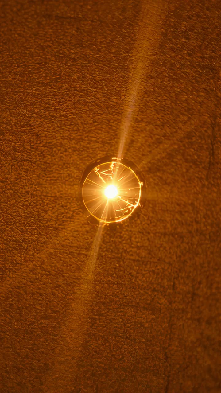 Vertical video: Shaking camera making ceiling light glare shifting in corridor, revealing diffuser