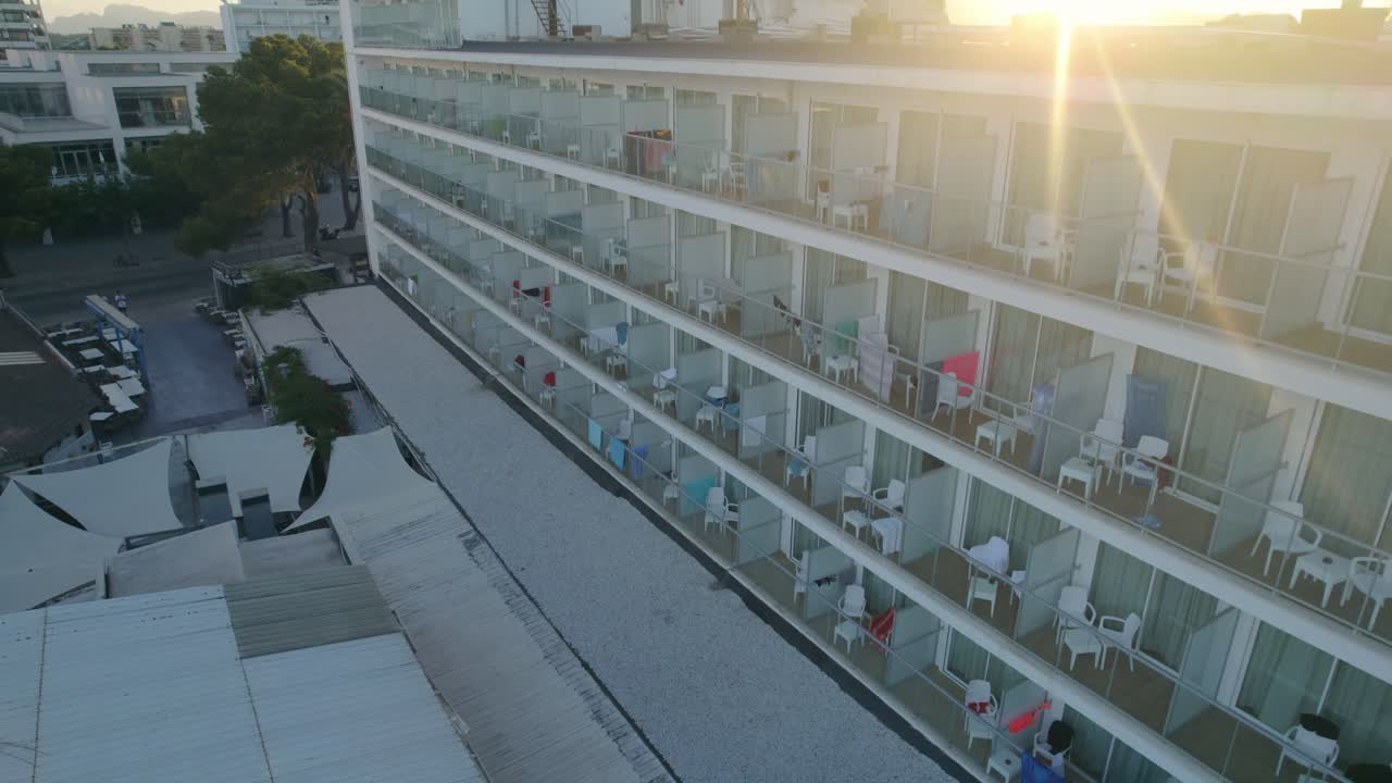 los rayos del atardecer proyectan un pintoresco resplandor en los balcones de un edificio de alojamiento turístico de cuatro pisos en mallorca, españa, encarnando la esencia de los conceptos de viaje y vacaciones.