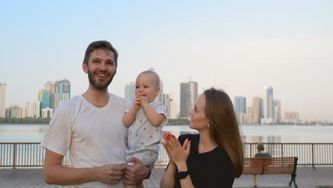 Mom-Dad-and-kid-laughing-and-hugging-enjoying-nature-outside.-Slow-motion.-The-boy-staggered.-4k