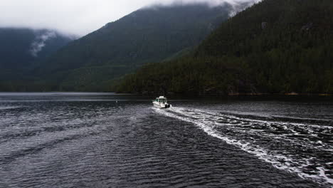 Motor-boat-cruising-on-sound-with-dramatic-scenic-natural-surroundings