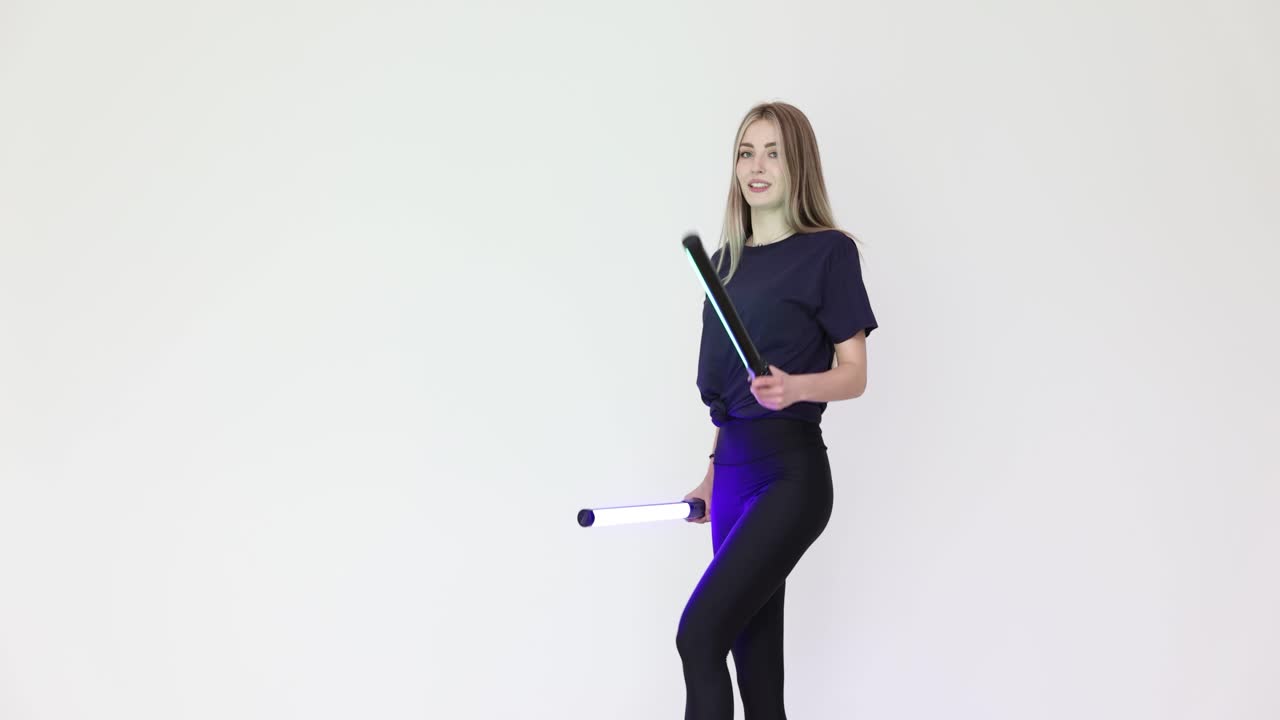 Woman Posing with Colorful LED Light Tubes in a Studio