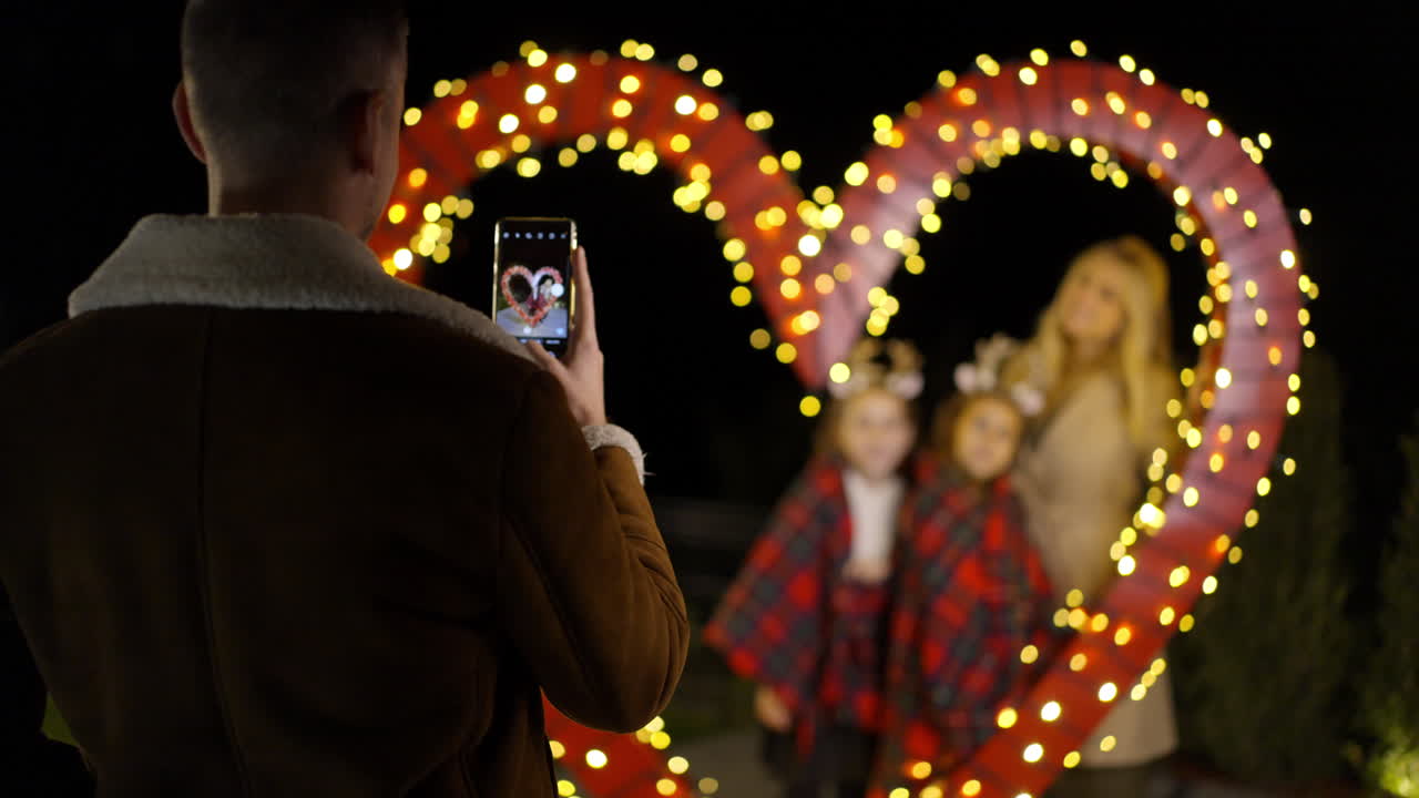 Family photo in front of heart-shaped lights