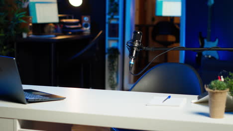 laptop on desk in empty home production studio