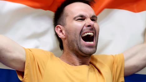 netherlands fan celebrating while holding the flag of netherlands in slow motion ,4k , high quality