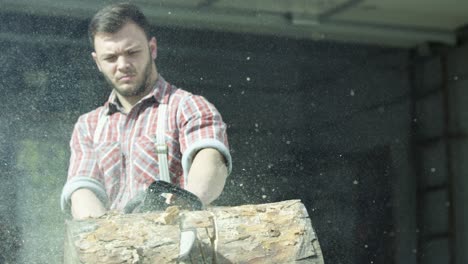 man using chainsaw to cut a log