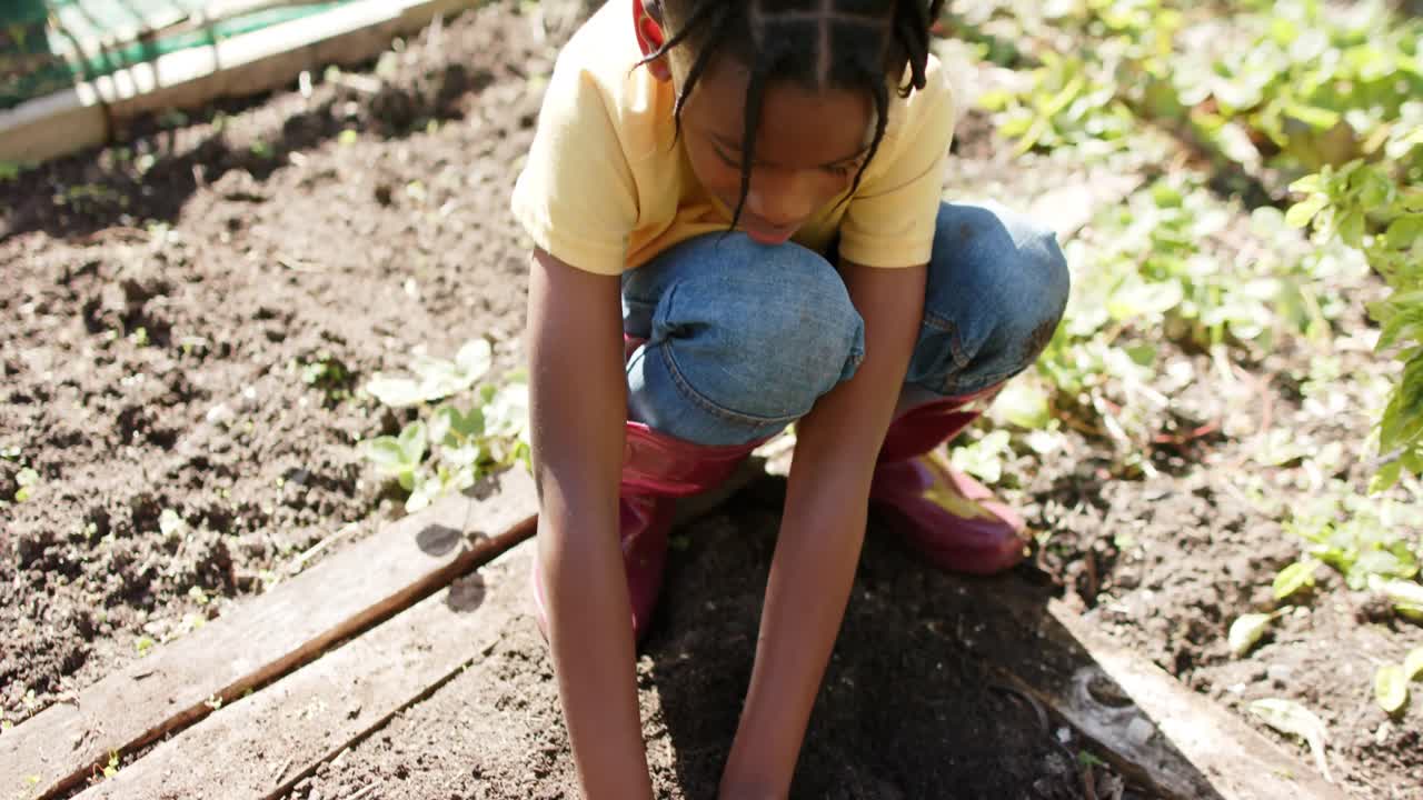 retrato de un feliz niño afroamericano que muestra las manos cubiertas de tierra, cámara lenta