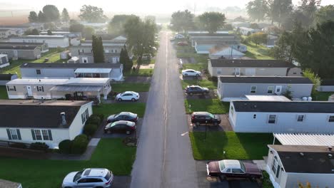 sunrise over a tranquil suburban street lined with mobile homes in trailer park