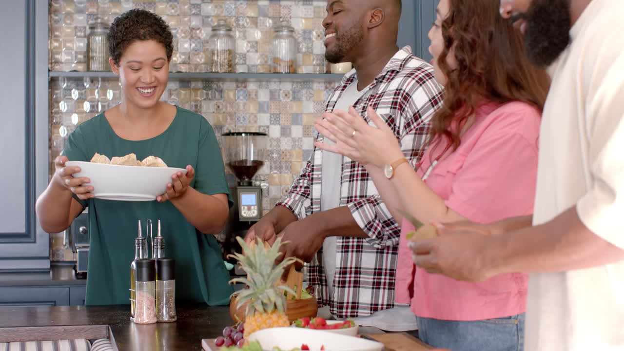Diverse group of friends preparing meal together in kitchen, enjoying time