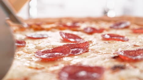 pizza pepperoni al estilo de nueva york cortada con cortador de pizza en cámara lenta y macro