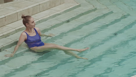 mujer joven sentada en la piscina
