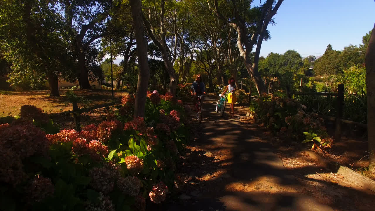 una pareja feliz montando una bicicleta en el parque