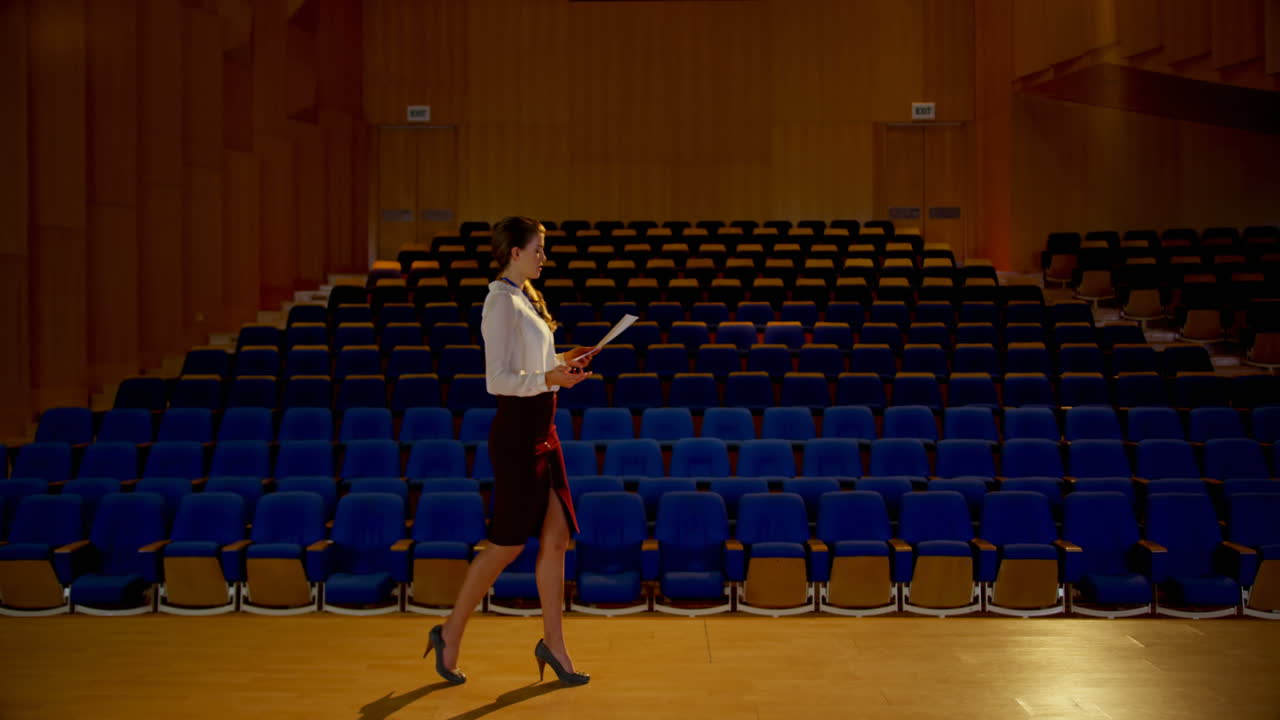 joven mujer de negocios caucásica practicando el discurso en un auditorio vacío 4k